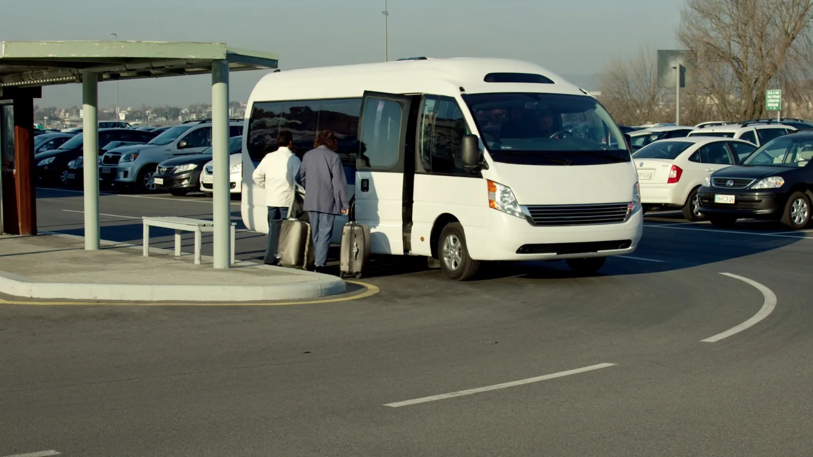 Van do traslado de um estacionamento em Confins recebendo passageiros com malas