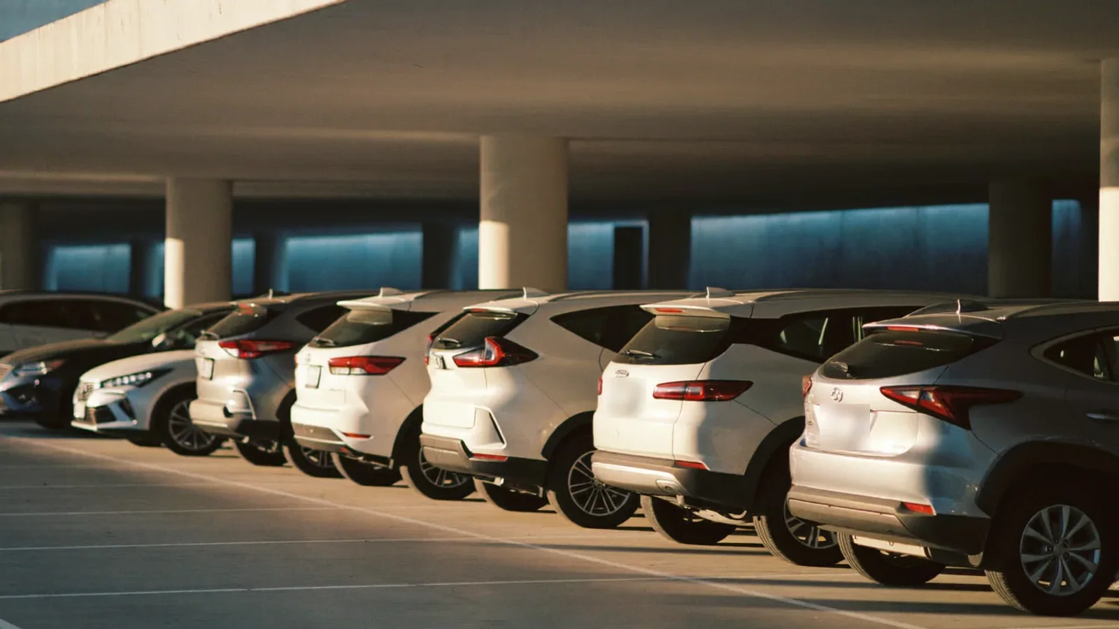 Vaga coberta de estacionamento perto do aeroporto CNF com carros recentes ao entardecer