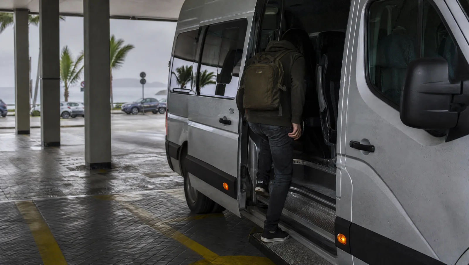 Van do traslado de um estacionamento barato em Florianópolis recebendo passageiro em dia nublado